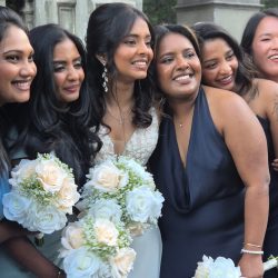 Bride posing with her bridal party in coordinated outfits