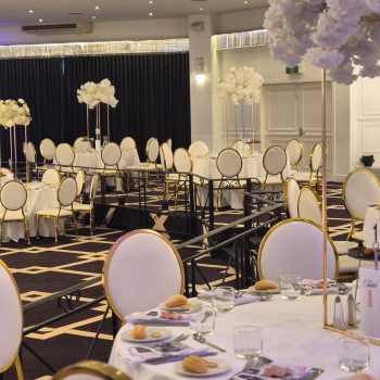Wide view of banquet hall with arranged guest tables.
