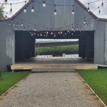Rustic barn wedding illuminated with warm bulb lighting