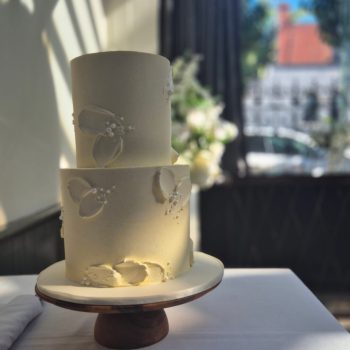 Elegant white two-tier wedding cake with simple decorative details