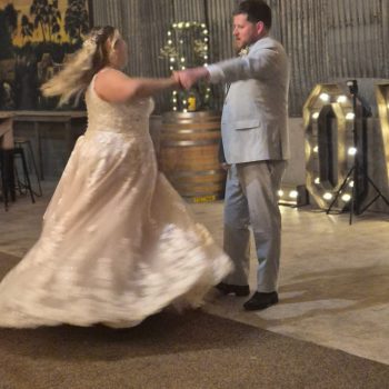 Bride twirling gracefully as she dances with the groom during their first dance