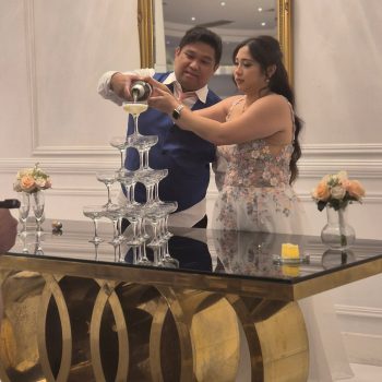 Couple pouring champagne into a tower during the celebration.