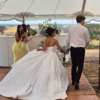 Bride and groom walking away with their backs facing the camera.