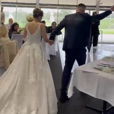Bride and groom making a joyful entrance together during their wedding celebration.