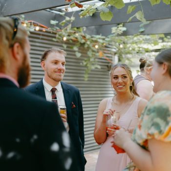 Guests chatting and laughing during candid wedding moments.
