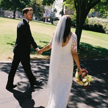 Bride and groom back view shot showing wedding attire against a scenic backdrop