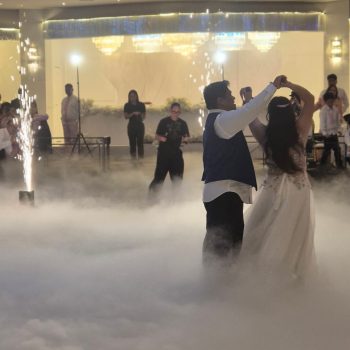 Couple dancing with bright sparklers glowing behind them.