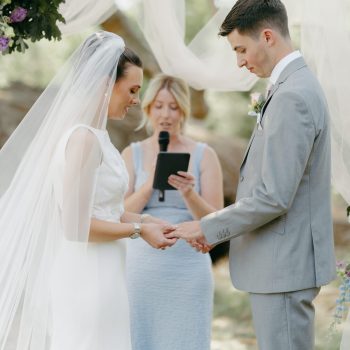 Couple holding hands while exchanging heartfelt wedding vows.
