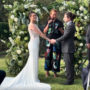 Bride and groom holding hands while exchanging vows.