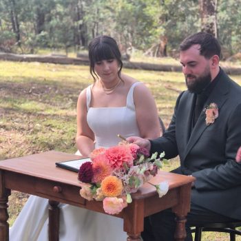 Couple preparing to sign their marriage documents during the ceremony.