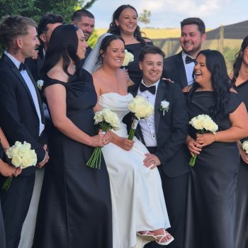 Wedding couple posing with bridesmaids and groomsmen outdoors
