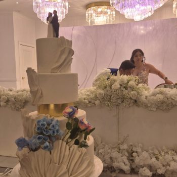 Tall multi-tiered wedding cake with elegant detailing.