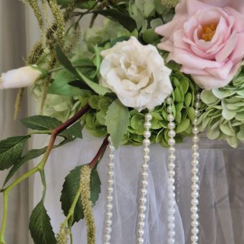 Soft white tulle fabric draped elegantly over a transparent pedestal for a romantic wedding ceremony.