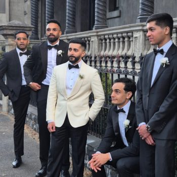 Groom standing with his groomsmen in coordinated outfits