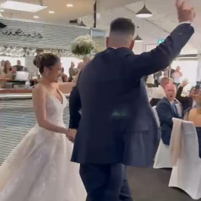 Bride and groom making a joyful entrance together during their wedding celebration.