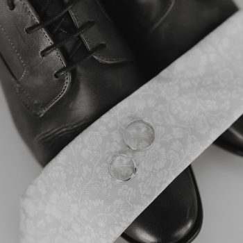 Close-up macro photograph of the couple's wedding bands placed together.