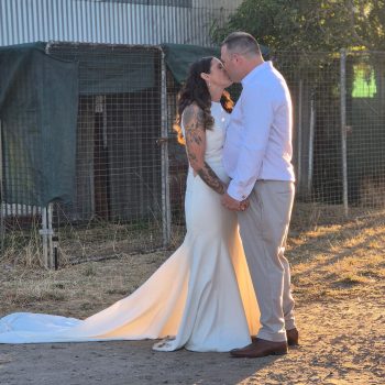 Newlyweds kissing outdoors, highlighting a joyful wedding celebration
