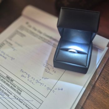 Wedding ring placed on top of marriage documents on a table