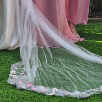 Closeup of a bridal veil laid softly on natural grass.