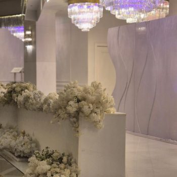 Elegant wedding stage decorated with white floral arrangements.